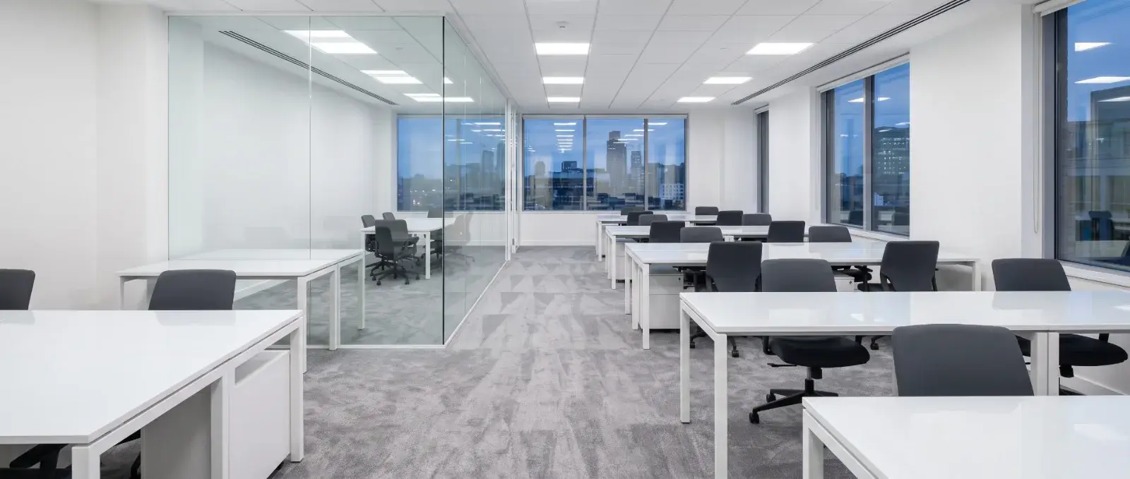 A cleaned open-plan office after hours, desks cleared and carpet freshly vacuumed