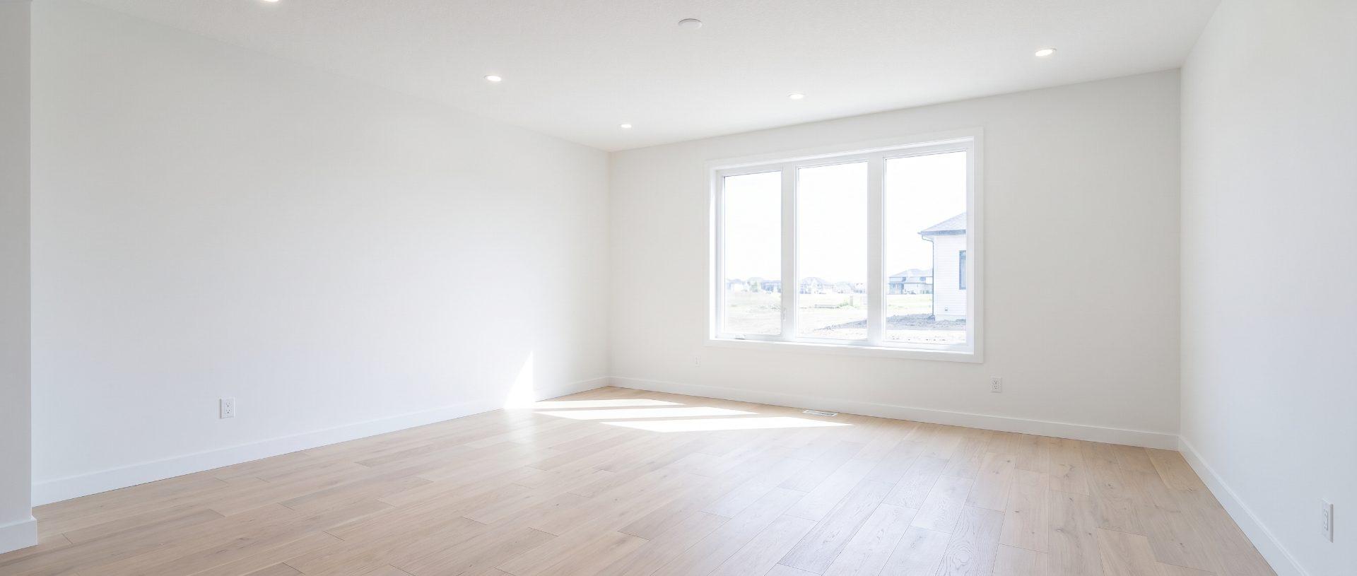 A newly finished room after a post-construction clean, floor swept and window glass cleaned
