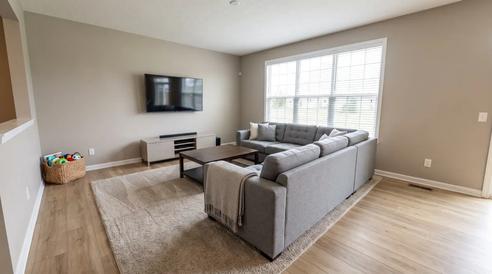 A family living room kept tidy between recurring visits, rug vacuumed and surfaces clear