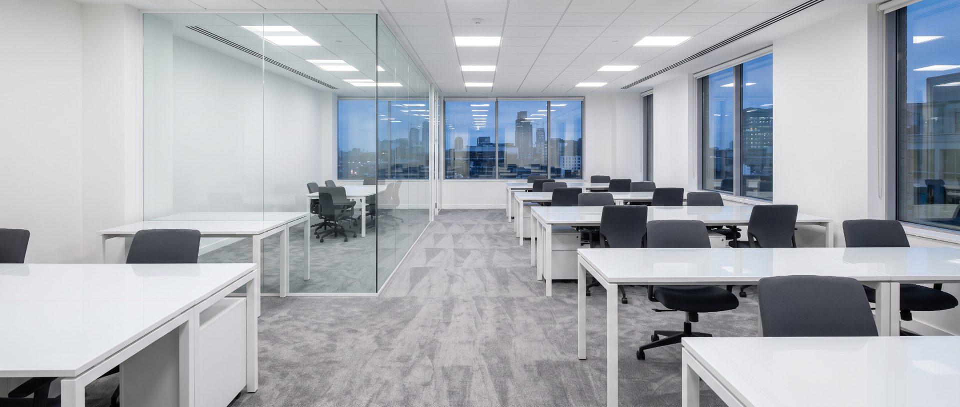 A cleaned open-plan office after hours, desks cleared and carpet freshly vacuumed